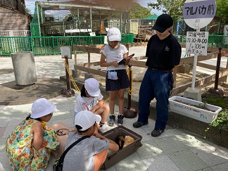 飼育員さんに相談する子供たちの画像